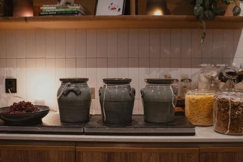 a kitchen counter with three vases on a counter top at Home Hotel Odin in Gothenburg