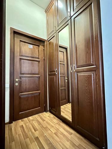 an empty hallway with two wooden doors and wood floors at NEW BELLA HOTEL in Yerevan