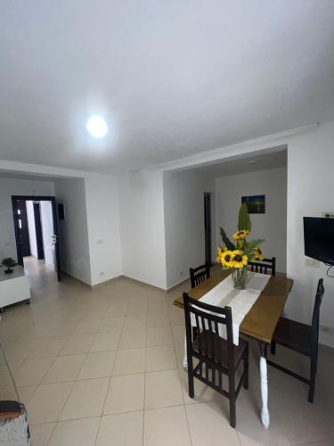 a living room with a table and chairs and a television at Hotel PEJA in Velipojë