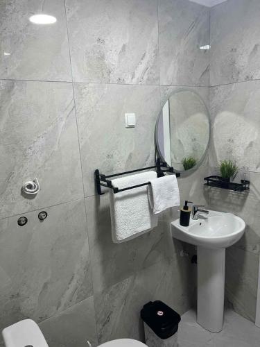a bathroom with a sink and a toilet and a mirror at Apartments Sunset Jovanoski in Ohrid