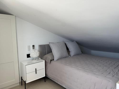 a white bedroom with a bed and a night stand at Panoramic Montain in Cabrils