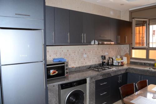 a kitchen with a stainless steel refrigerator and a dishwasher at Agadir airport guest house in Ikhorbane