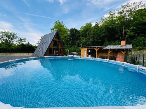 a large swimming pool in front of a house at Cabana Twins A-Frame 2 in Sibiu