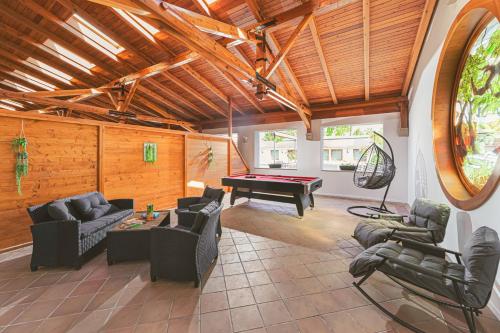 a living room with couches and a pool table at Park Hotel Bükfürdő in Bük