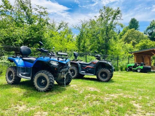 two atvs and a quad bike parked in a field at Cabana Twins A-Frame 2 in Sibiu