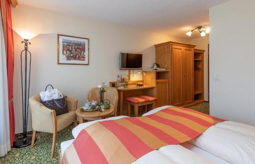 a hotel room with a bed and a desk at SALZANO Hotel - Spa - Restaurant in Interlaken