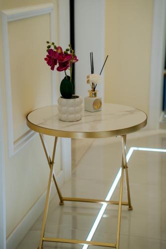 a small table with a vase of flowers on it at Luxury Acclavio Apartments in Taranto