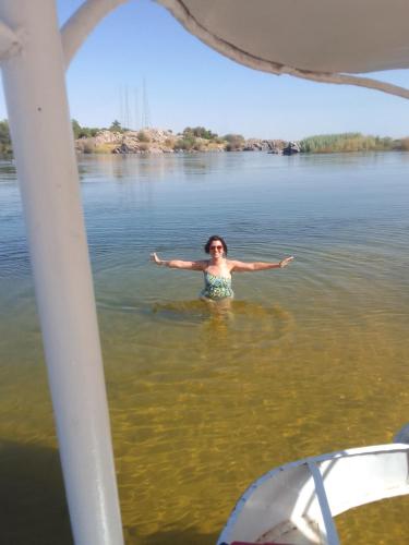a woman standing in the water on a boat at Nubian Life Nile View in Aswan