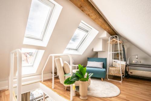 a attic room with skylights and a blue chair at Altstadt Auszeit in Freiburg im Breisgau