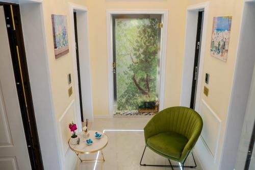a living room with a green chair and a table at Luxury Acclavio Apartments in Taranto