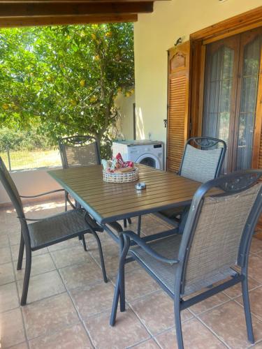 a wooden table and chairs on a patio at Angel's Heaven in Sikia