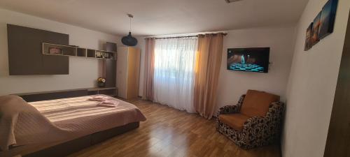 a bedroom with a bed and a chair at Casa Geo in Vadu