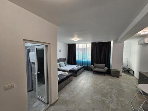 a room with a bed and a couch and a chair at LA PLAYA - Camere pe plaja cu sezlong gratuit in Eforie Nord