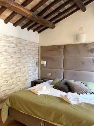 a bedroom with a large bed with a stone wall at Ah Suite Trevi in Rome