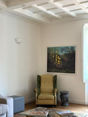 a living room with a chair and a painting on the wall at Ah Suite Trevi in Rome