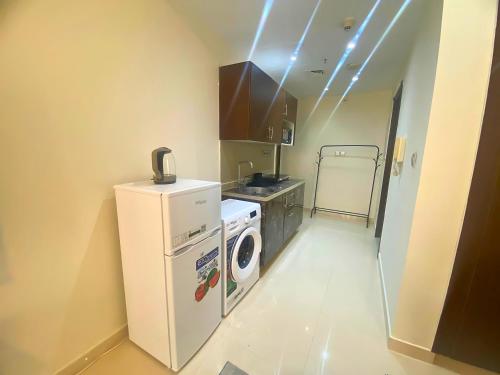 a kitchen with a washing machine and a washer at Studio Apartment Near Deira City Centre Mall and Metro with Gym and Pool in Dubai