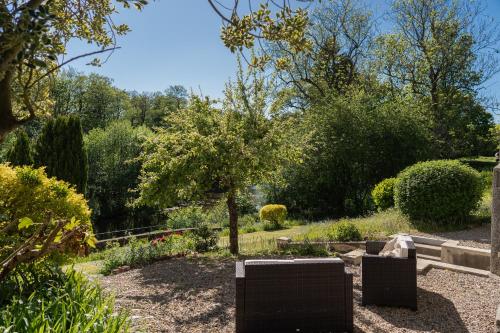 a garden with two chairs and a tree at Host & Stay - St Mary's Riverside in Whitby