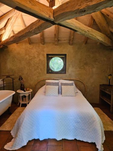 une chambre avec un lit, une baignoire et une fenêtre dans l'établissement Petit paradis, à Lavaur