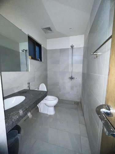 łazienka z umywalką, toaletą i lustrem w obiekcie Sunrise Villa w mieście Islamabad