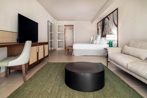 a living room with a couch and a tv at Hotel Ritual de Terra & SPA Moraira in Moraira