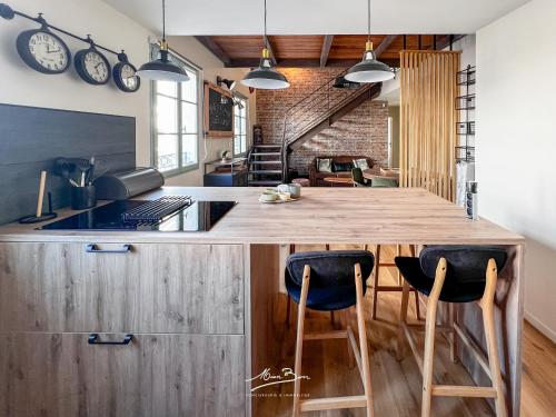 une cuisine ouverte avec un comptoir en bois et des chaises dans l'établissement Un loft d exception au cœur de Toulon 4 chambres wifi, à Toulon
