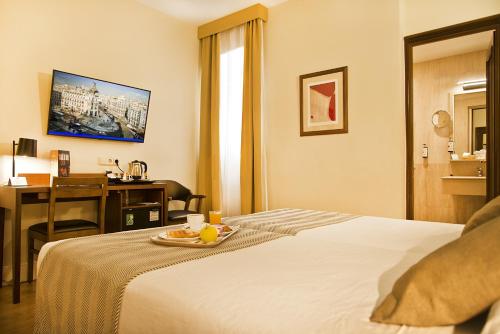 Кровать или кровати в номере Hospedium Hotel Los Condes