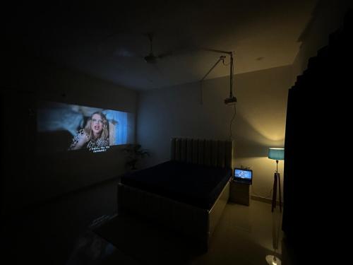 a living room with a tv in a dark room at The Happy Hangout in Zirakpur