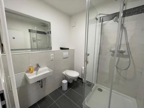 a bathroom with a shower and a toilet and a sink at Appartementhaus Strausberg-Nord in Strausberg