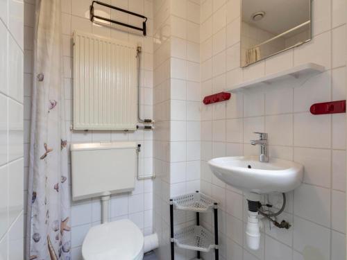 a white bathroom with a sink and a toilet at Villa in Julianadorp near Sandy Beach in Julianadorp