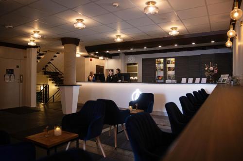 a bar in a restaurant with chairs and a counter at Hotel Adlon in Mariehamn