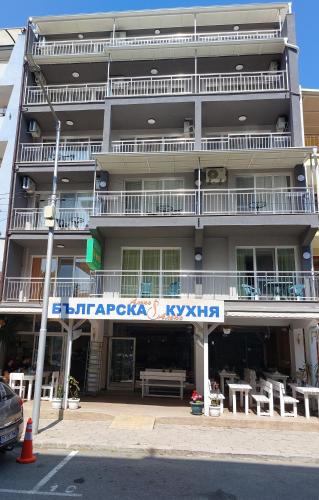 an apartment building with a sign in front of it at Guest house WEST in Sunny Beach
