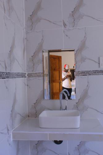 eine Person, die ein Bild von einem Badezimmerspiegel macht in der Unterkunft Paradise Reho Guesthouse in Nata