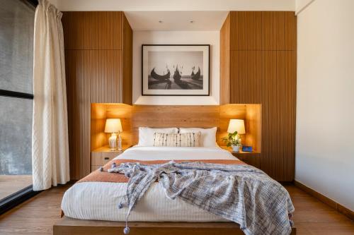 a bedroom with a large bed with wooden walls at SaffronStays Rio in Nerul