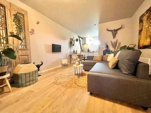 a living room with a gray couch and a table at Gîte "Ibiza" in Chamblet