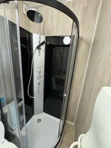 une douche dans une petite salle de bain avec un miroir dans l'établissement Le 27 Deauville, à Deauville