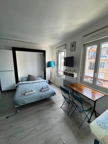 une chambre avec un lit, une table et un bureau dans l'établissement Le 27 Deauville, à Deauville