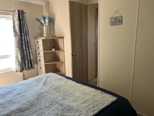 a bedroom with a bed and a window and a door at Sher, My Happy super static in Llanddwywe