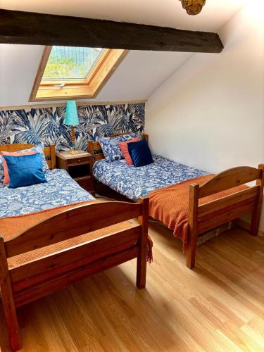 une chambre avec deux lits et une fenêtre dans l'établissement La petite nid, à La Celle-sous-Gouzon