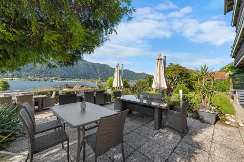 a patio with a table and chairs and umbrellas at Pension Magdalena in Altossiach