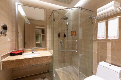 a bathroom with a shower and a toilet and a sink at Ramada by Wyndham Zhangjiajie Tianmen Mountain in Zhangjiajie