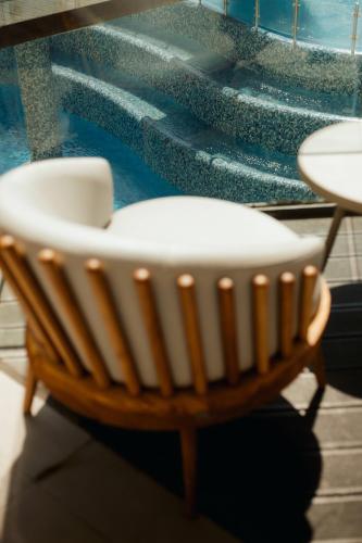 a wooden chair sitting in front of a window at Melissi Beach Hotel & Spa in Ayia Napa