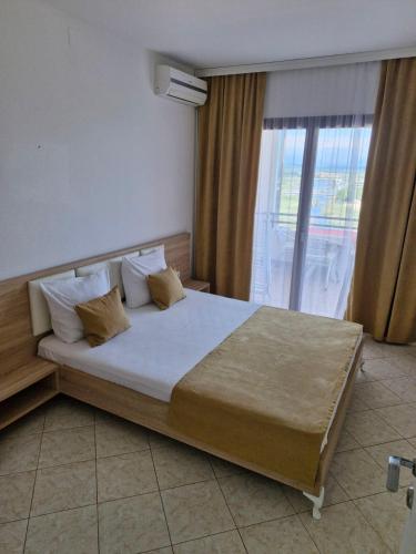 a bedroom with a large bed and a window at Aparments Plaza in Velika Plaža