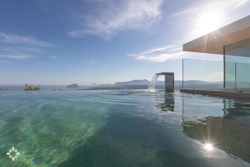 a swimming pool with a fountain in the water at Villas Aloe Vera by Abahana Luxe in Benitachell