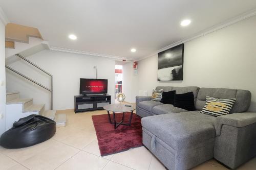 a living room with a couch and a tv at Casa Madureira - Paraíso centenário do Douro in Sabrosa