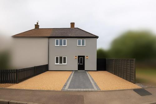 ein großes weißes Haus mit einem schwarzen Zaun in der Unterkunft Modern Gilliver House Rural retreat sleeps 7 in Barlestone