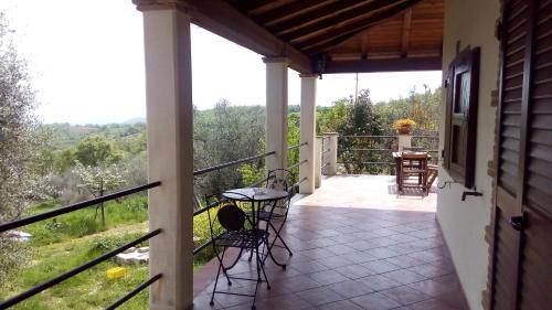 uma varanda de uma casa com uma mesa e cadeiras em Agriturismo La Chiocciola em Poggio Murella