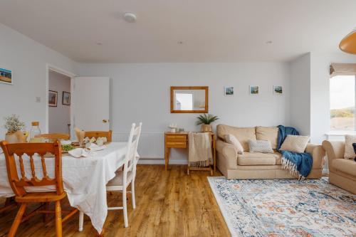 a living room with a table and a couch at Sandy Shores Apartment in Swanage