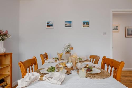 a table with plates of food on top of it at Sandy Shores Apartment in Swanage