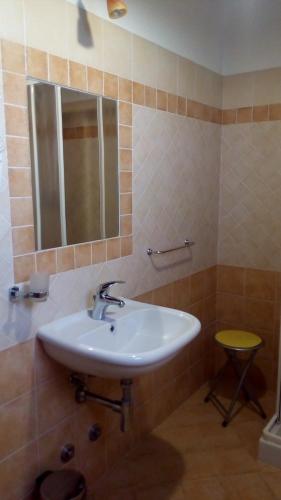 a bathroom with a sink and a mirror and a stool at Agriturismo La Chiocciola in Poggio Murella
