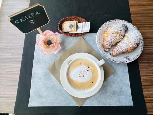 a cup of coffee and a plate of pastry on a table at Hotel Ristorante Radar in Carrara